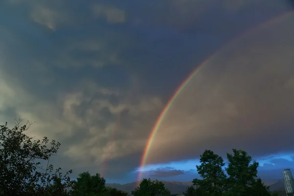 暗い嵐の空の背景に虹 — ストック写真
