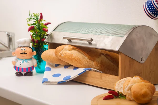 Baguette, acostada en una caja de pan, hecha de madera con tapa de metal Fotos De Stock Sin Royalties Gratis