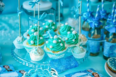 Mavi krema ve şeker boncuk sopa üzerinde cupcakes süslenmiş