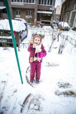 Karla kaplı sokakta oynayan kız