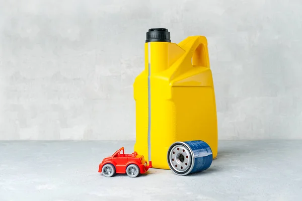 黄色のオイルキャニスター オイルフィルターと小さな車で車のエンジンオイル交換の概念 — ストック写真