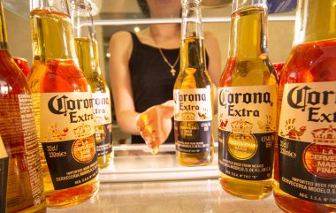 KHARKIV, UKRAINE - 28 Kasım 2020: Corona Bira Şişeleri 'nin illüstrasyon editörü. Kızın eli buzdolabından bir şişe Corona Extra Birası çıkardı. İç görünüm. 