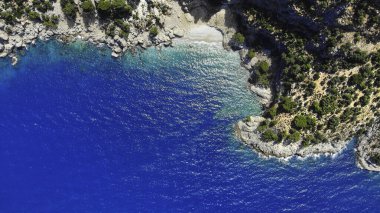 Deniz suyunun havadan görünüşü ve kayaların arasındaki güzel körfez. İnsansız hava aracından Akdeniz doğası üst görünümü.