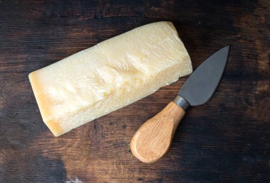Otantik ahşap tahtanın üzerinde peynir ve peynir bıçağı var. 