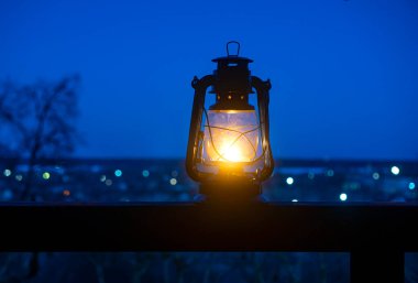 Arka planda antik gazyağı lambası ile rahatlamak masaya karşı manzara ile Bokeh.