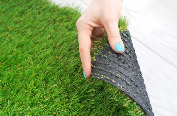 Tender Female Hand Touching Artificial Grass Roll — Stock fotografie