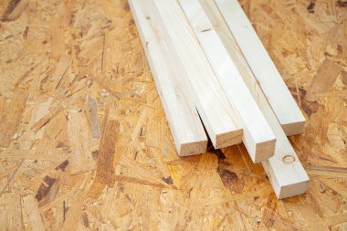 Devekuşu çarşafının üzerinde duran ahşap madde. İnşaat ve onarım. Kopya alanı olan bir arkaplan.