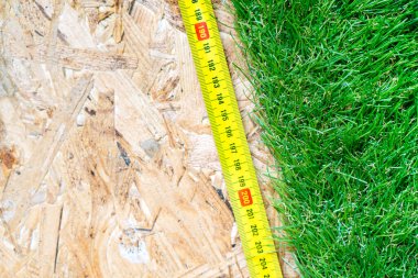 Yapay çim rulosunda yatan paten bandı devekuşu zemininde yatıyor. Kopyalama alanı olan arkaplan.