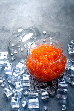 Cam bir kavanozda soğutulmuş kırmızı havyar. Dikey.