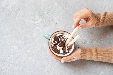 Marşmelovlu sıcak kakao kupası, waffle ve kadın ellerinde sıcak çikolata. Üst Manzara. Boşluğu kopyala.
