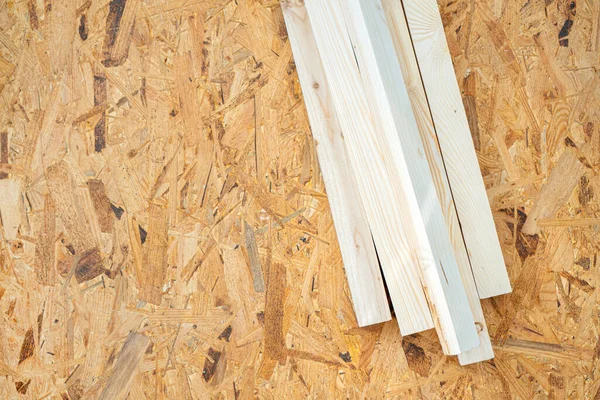 Devekuşu çarşafının üzerinde duran ahşap madde. İnşaat ve onarım. Kopya alanı olan bir arkaplan.