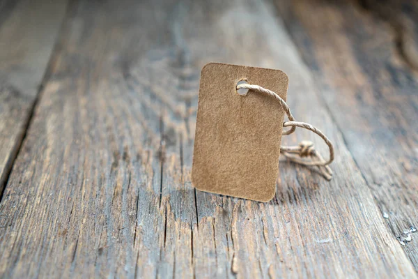 Eski ahşap arka planda duran etiketiniz için karton fiyat etiketi ya da boş etiket. Boşluğu kopyala.