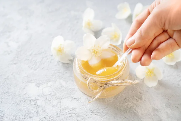 Woman Hand Takes Spoon Natural Honey Decorated Flowers — Stock Photo, Image