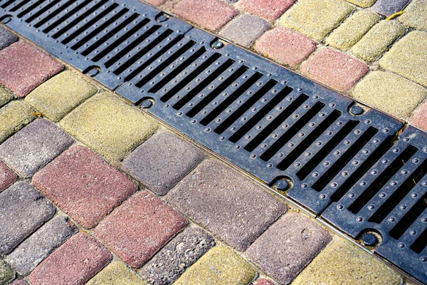 雨水は舗装内の排水システムを鋳造します 排水や歩道からの水の分離に使用されます — ストック写真