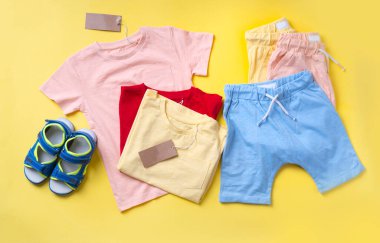 Sarı fırında çocuk kıyafetleri, şortları ve sandaletleri.