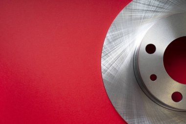 Kopya alanı olan araç frenleme sistemi arkaplanı. Kırmızı arka planda araba diski fren kısmı.