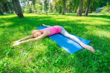 Genç kız yoga yapıyor ve şehir parkında esneme hareketleri yapıyor. Pistte sicim eğitir.. 