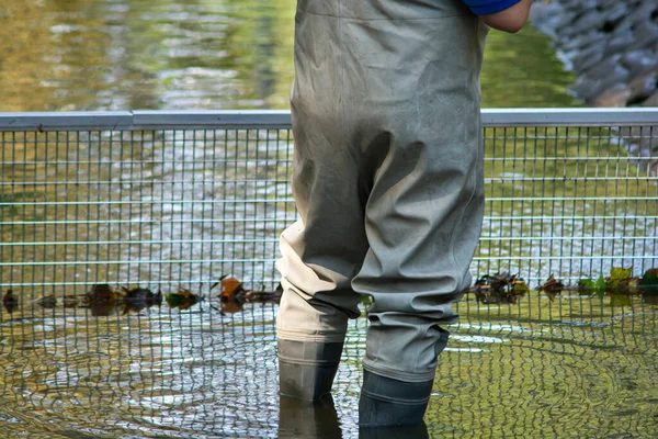 站在池塘里的穿着高捕捞胶靴的男人 — 图库照片