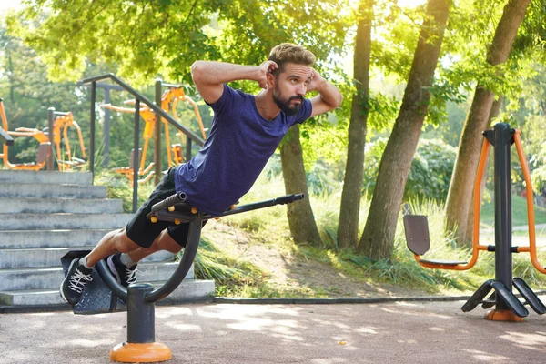 Uzatma egzersizi. Şehir parkındaki yedek kulübesinde formda adam eğitimi. Spor salonu aç..