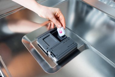 Elle bulaşık makinası deterjanı tabletine yerleştirir - tablet, deterjan, bulaşık makinesi, temiz, bisiklet.