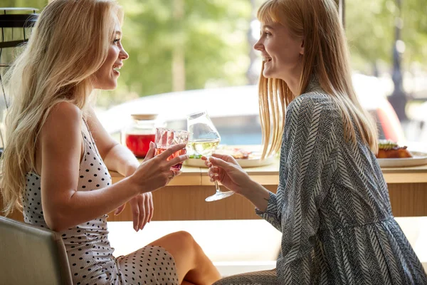 Women friends meeting up, sitting in cafe, smiling and laughing — Stock Photo, Image