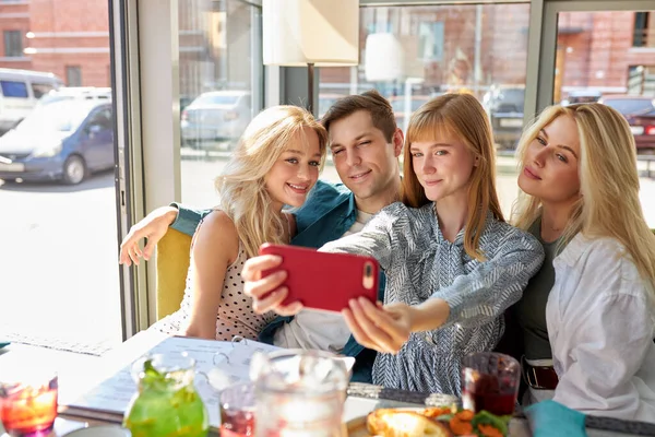 Personas caucásicas alegres posando para la foto en la cafetería juntos, selfie en el teléfono inteligente — Foto de Stock