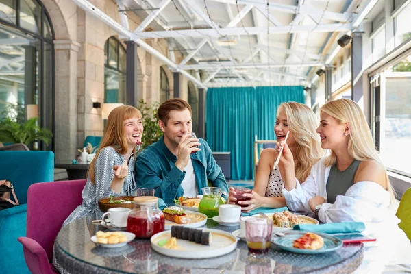 Χαρούμενους Καυκάσιους φίλους που περνούν χρόνο μαζί σε φωτεινό ζεστό χρόνο cafe — Φωτογραφία Αρχείου