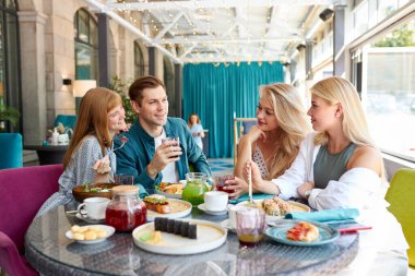 Kafede toplanan, masada oturan, sohbet eden, sohbet eden mutlu beyaz arkadaşlar.