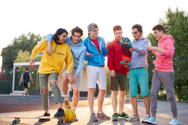 Sportif gençler sokakta basketbol oynayacaklar.