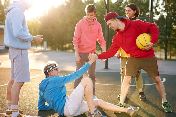 Kompisar nå ut till en fallen vän — Stockfoto