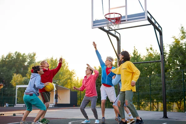 Grupp unga manliga tonåringar spelar basket utomhus — Stockfoto