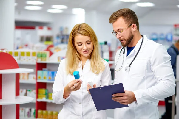 Dwóch kolegów farmaceutów realizujących receptę trzymających leki w ręku — Zdjęcie stockowe