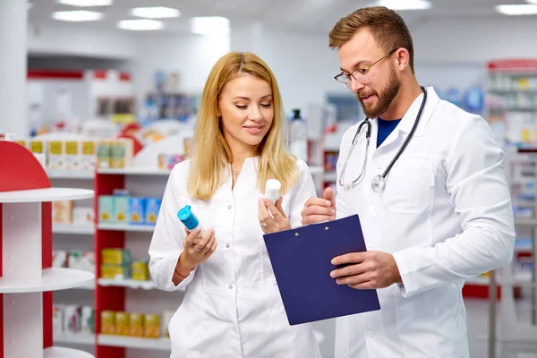 Dwóch kolegów farmaceutów realizujących receptę trzymających leki w ręku — Zdjęcie stockowe