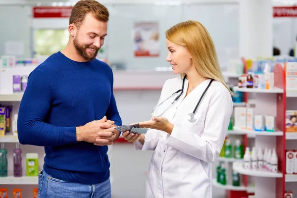 male customer having a discrete talk with druggist in pharmacy