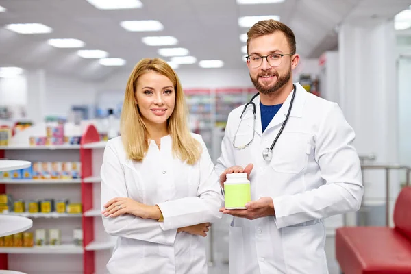 Zespół dwóch farmaceutów pokazuje prezentację pudełka z lekami w aptece — Zdjęcie stockowe