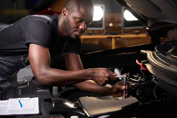 Africano profesional técnico de servicio de automóviles de pie cerca de la reparación de la capucha del coche y el uso de coche inspeccionar lista de verificación — Foto de Stock