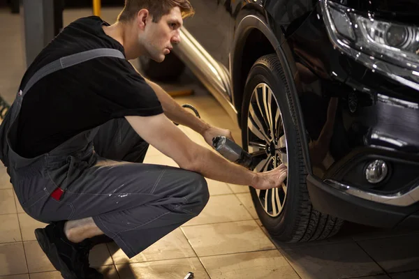 Maschio sta riparando ruota auto da solo — Foto Stock