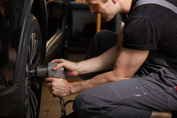 Male is repairing car wheel alone — Stock Photo, Image