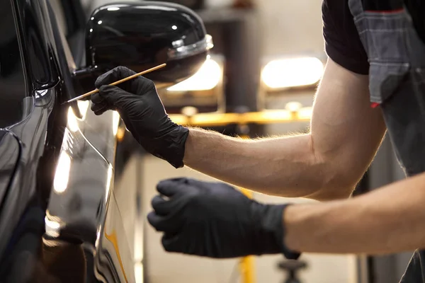 Recortado caucásico auto servicio trabajador está pintando detalles del coche — Foto de Stock