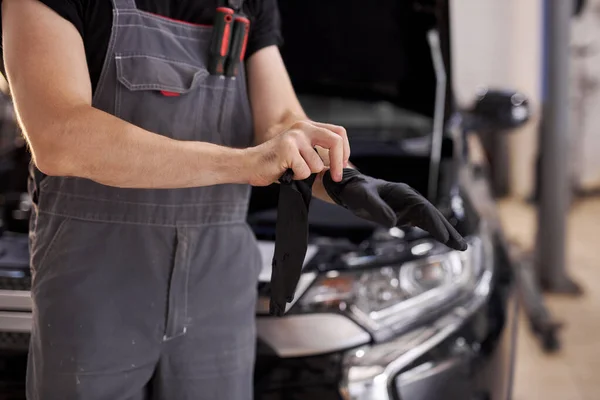 Nahaufnahme eines Autoservice-Mitarbeiters mit schwarzen Handschuhen — Stockfoto
