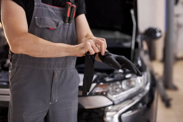 Foto de primer plano del trabajador de servicio automático con guantes negros — Foto de Stock