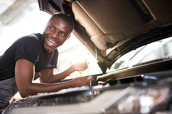 Vrolijk glimlachen afro man genieten van het repareren van auto 's kap — Stockfoto