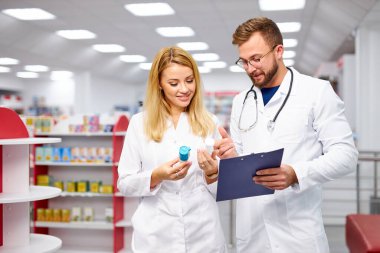 İki Kafkasyalı eczacı dijital tablet kullanarak ilaçları tartışıyor.