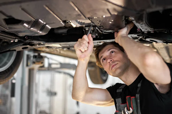Mecánico masculino está trabajando en un vehículo en un servicio de coche, solo — Foto de Stock
