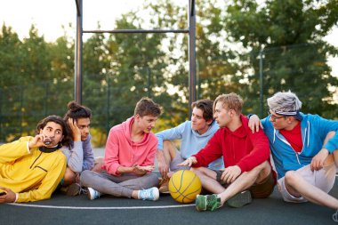 Rahatlamış erkek gençler spor oyunlarından sonra dinleniyor.