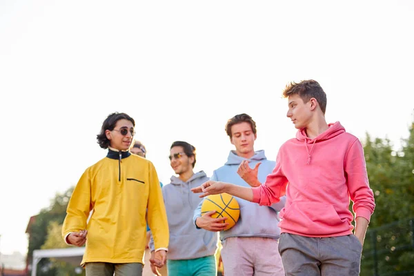 Meninos esportivos que vão jogar basquete na rua — Fotografia de Stock