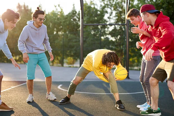 Adolescentes meninos jogando basquete na quadra ao ar livre, playground e se divertindo — Fotografia de Stock