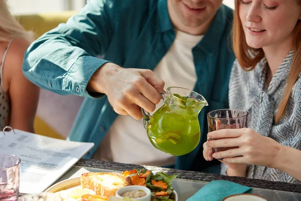 L'uomo galante versa il succo dolce in occhiali per donne, li tratta — Foto Stock