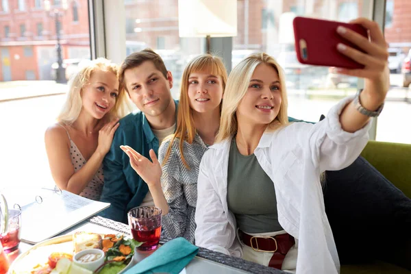 Retrato de grupo feliz de amigos tomando fotos en el teléfono inteligente — Foto de Stock