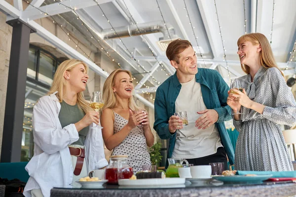 Fiesta en la luz acogedor restaurante. amigos divertirse, hablar — Foto de Stock